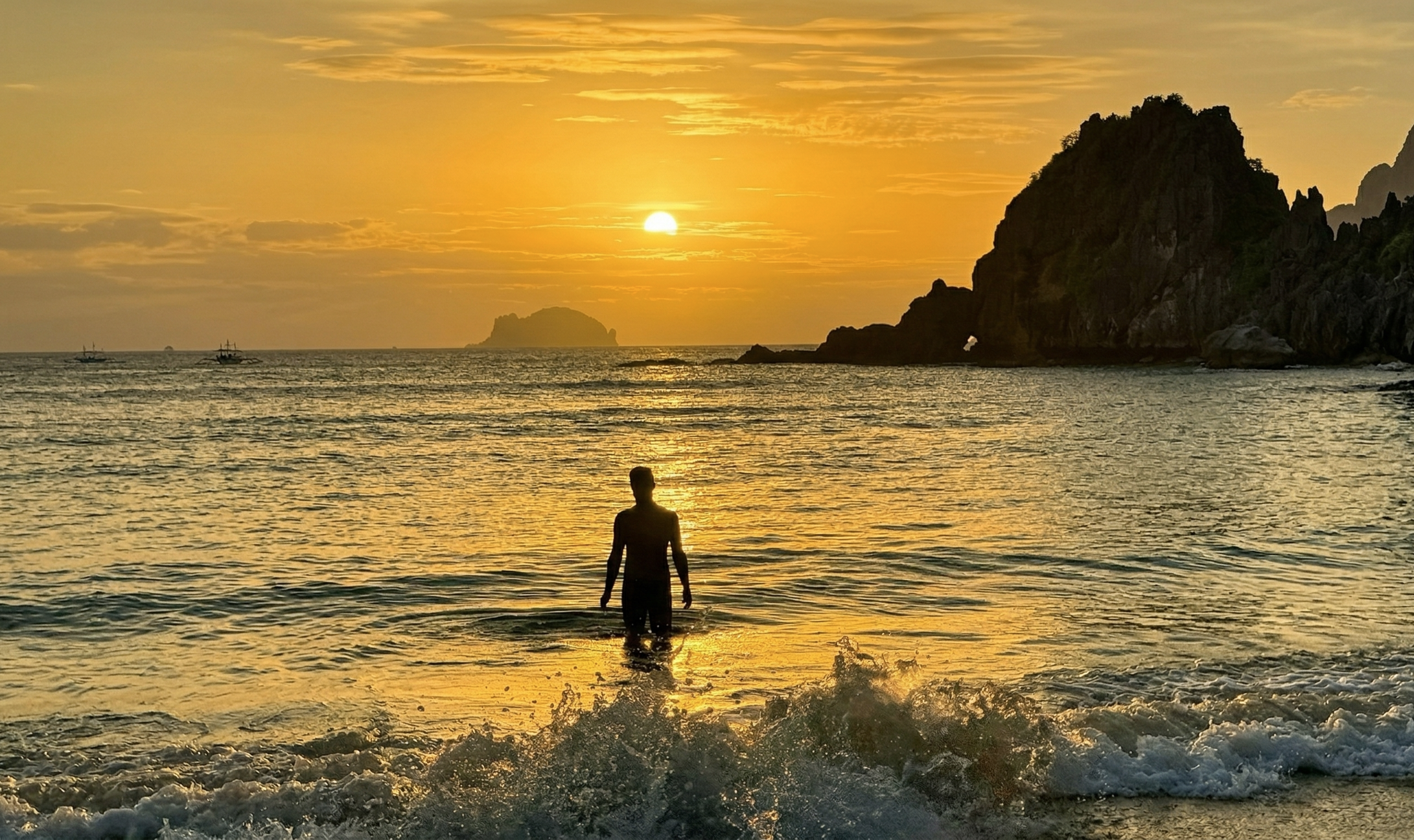 Sunset silhouette — Henry Ngai standing in the ocean at golden hour